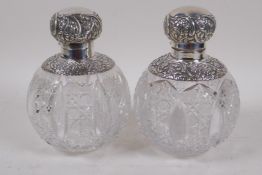 A near pair of cut glass bulbous cologne decanters with hallmarked silver tops, London 1893/94, 16cm