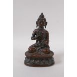 A bronze figure of Buddha seated upon a lotus throne, well patinated, the cast filled with lead,