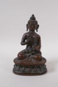 A bronze figure of Buddha seated upon a lotus throne, well patinated, the cast filled with lead,