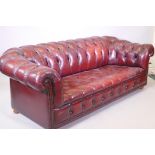 A red leather three seater chesterfield sofa