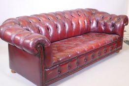 A red leather three seater chesterfield sofa