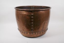 A large antique copper riveted bucket with historic repairs, 31cm high x 42cm diameter