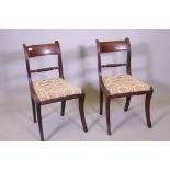 A pair of Regency mahogany side chairs, with ebony inlaid backs raised on sabre supports