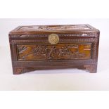 An oriental camphorwood coffer with brass hasp and carved decoration, raised on bracket supports,