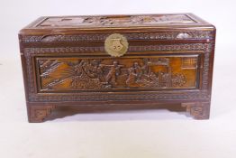An oriental camphorwood coffer with brass hasp and carved decoration, raised on bracket supports,