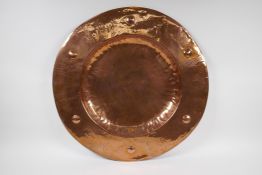 An antique copper Newlyn style charger, 57cm diameter