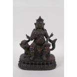 A Sino Tibetan bronze of an armoured deity seated on a kylin, with the remnants of gilt and