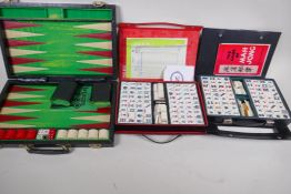 A cased backgammon set and two cased mahjong sets