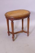 A French beechwood stool, with caned seat and carved frieze, raised on turned fluted supports united