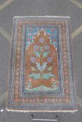 A Persian tan and turquoise ground wood rug with unique thistle design, 124cm x 190cm
