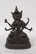 A Sino Tibetan bronze figure of a many armed deity seated on a lotus throne, 17cm high