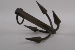 A decorative bronze desk weight in the form of a four pronged hook, 26cm long