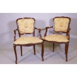 A pair of French style stained beechwood elbow chairs with carved decoration, raised and cabriole