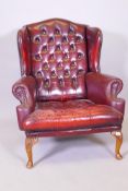 A red buttoned leather wingback armchair