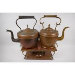 A vintage brass and copper warming stand, 42cm wide, and two C19th copper and brass kettles