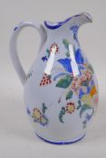 A C19th Quimper pottery jug painted with a floral cornucopia, 21.5cm high