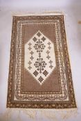 A Tunisian cream ground geometric rug with brown borders, 118cm x 190cm