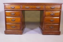A late Victorian walnut pedestal desk with nine moulded drawers and tooled leather inset top,