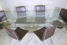 A glass top dining table with chrome base and splay supports and a set of six chairs en suite with