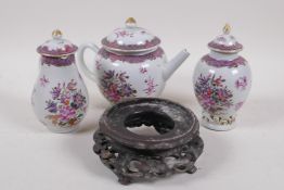 A Chinese export ware porcelain three piece tea set painted with flowers and a Chinese carved wood