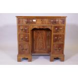 A Georgian style mahogany kneehole desk, with seven oak lined and cock beaded drawers, and slide