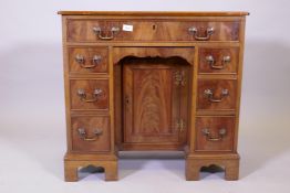 A Georgian style mahogany kneehole desk, with seven oak lined and cock beaded drawers, and slide