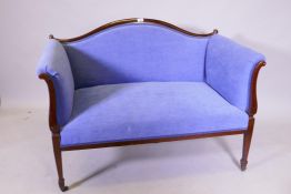 A Victorian mahogany two seat settee with humpback and scroll arms, raised on square tapering