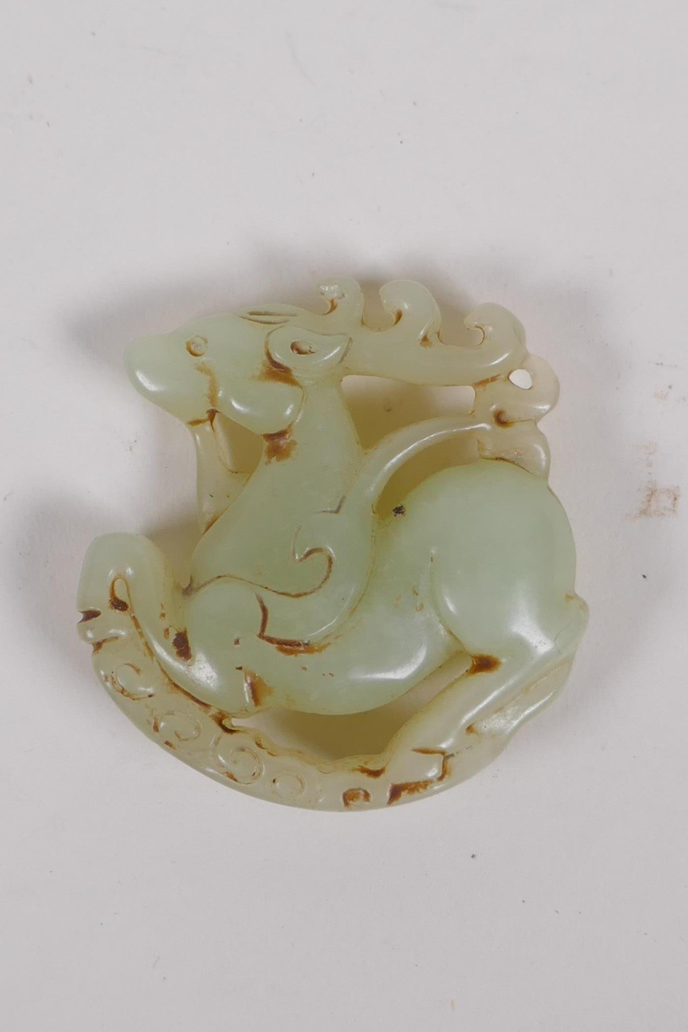 A Chinese carved celadon jade deer pendant, 5cm diameter