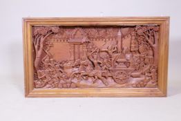 A Thai framed carved teak panel, depicting a procession of gods and immortals, 103cm x 63cm x 13cm