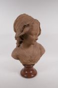 A C19th terracotta bust of a young girl in a bonnet, mounted on a marble socle, 46cm high