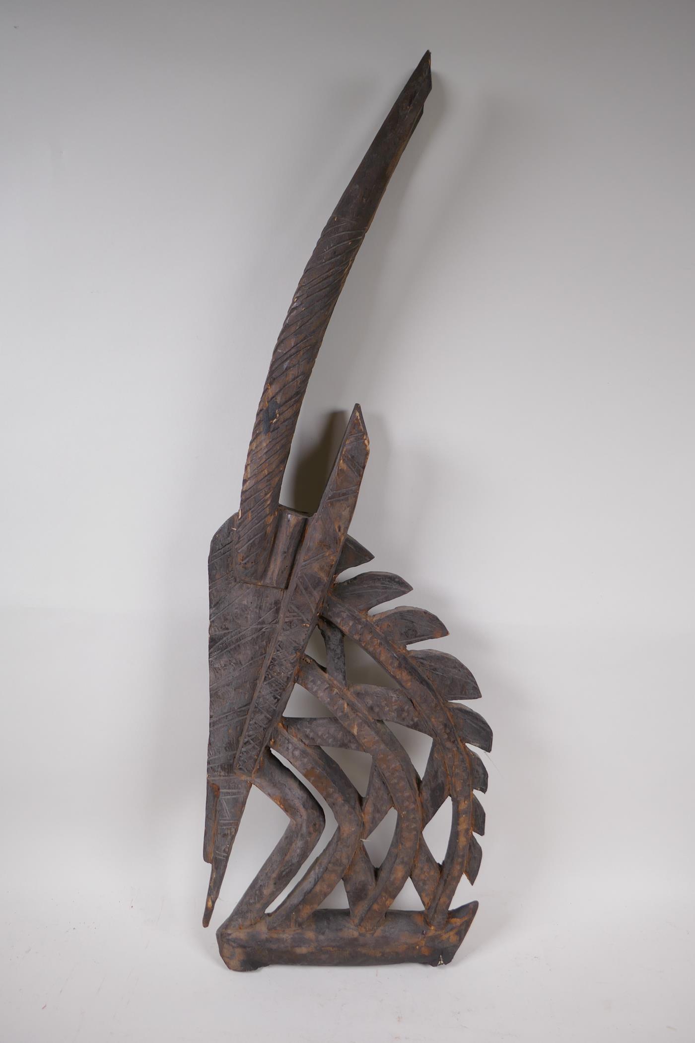 An African carved wood antelope bust, 71cm high