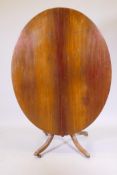 A Victorian over shaped walnut tilt top breakfast table, with reeded edges raised on turned column