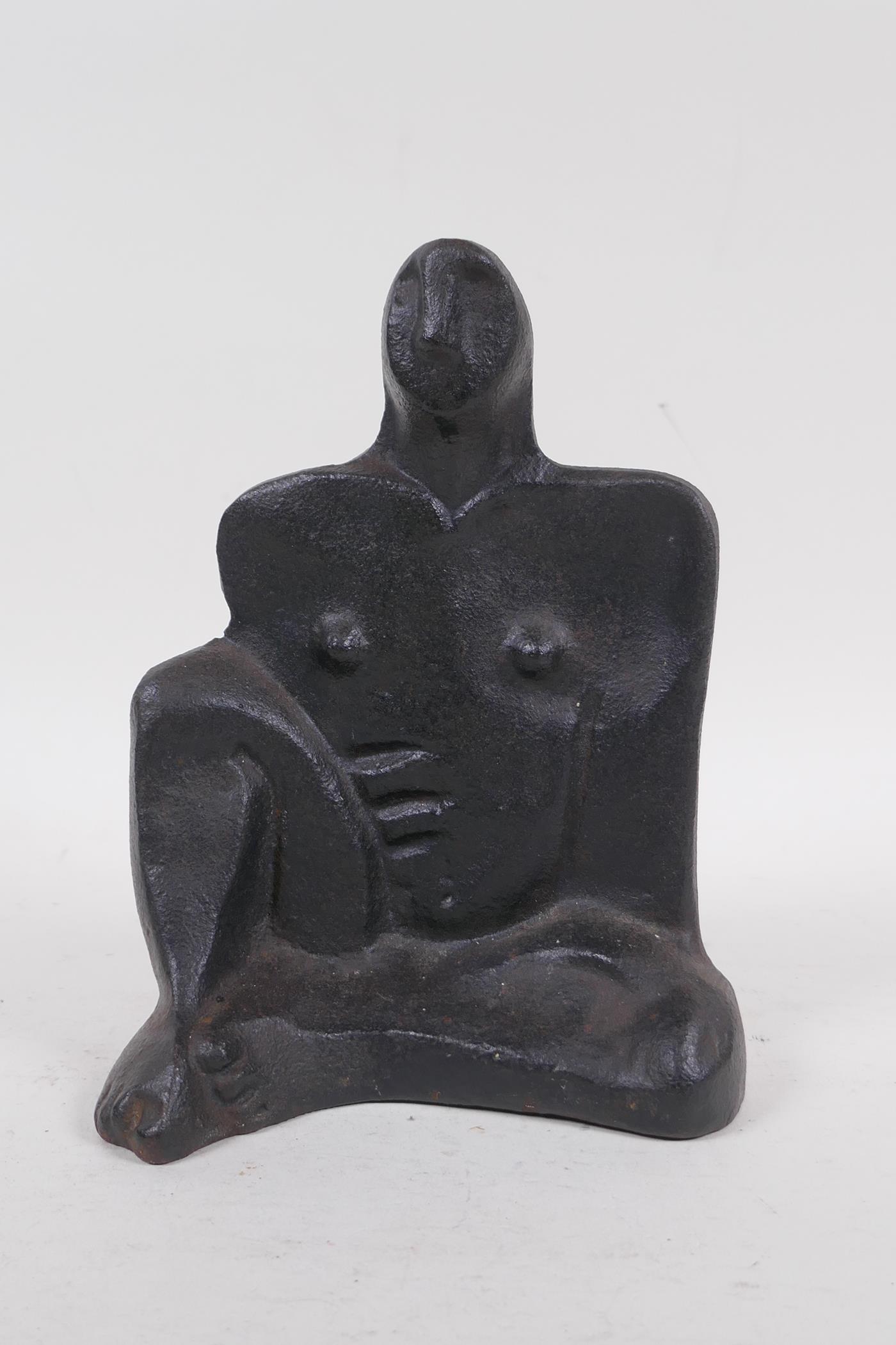 A cast iron figure of a nude in the manner of Henry Moore, stamped M.N., 19cm high
