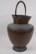An eastern copper water jug with double spout and loop handle, 40cm high