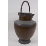 An eastern copper water jug with double spout and loop handle, 40cm high