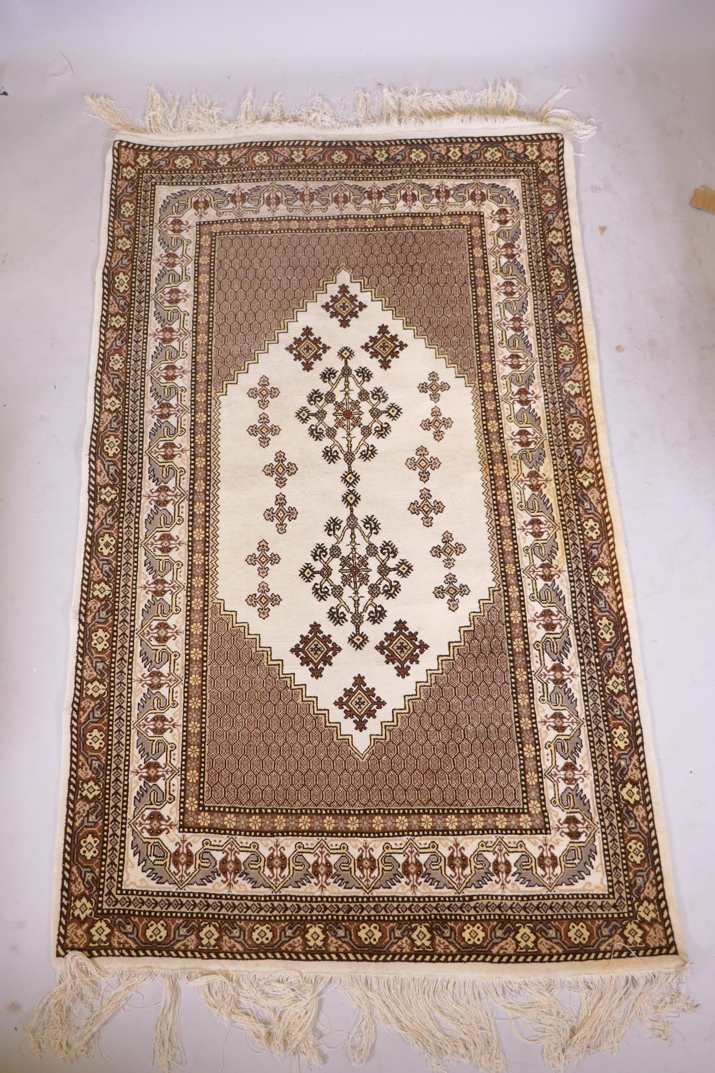 A Tunisian cream ground geometric rug with brown borders, 118cm x 190cm