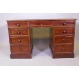 A Victorian mahogany pedestal desk, nine drawers with moulded details and wood knobs, and a tooled