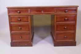 A Victorian mahogany pedestal desk, nine drawers with moulded details and wood knobs, and a tooled