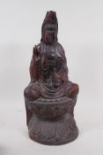 A hardwood carving of Quan Yin, seated upon a lotus throne, 40cm high