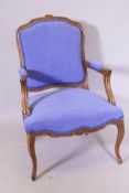 A French beechwood open arm chair with carved decoration, recently re-upholstered