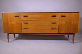 A mid century E Gomme, G Plan teak dressing table with two cupboards flanking three drawers,