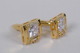 A pair of gilt metal cufflinks set with cubic zirconia