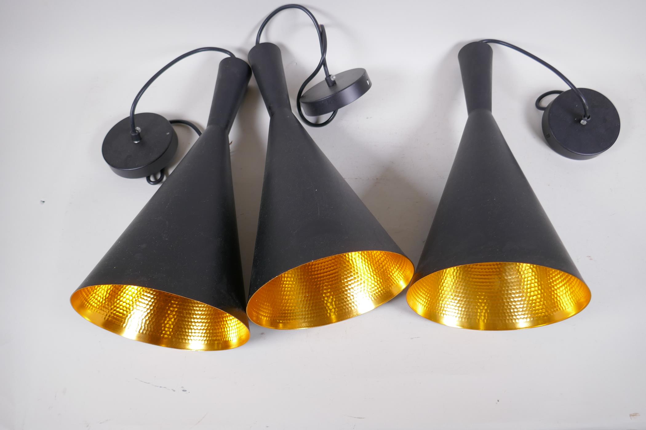 Three black and gilt studio lamps, 39cm high