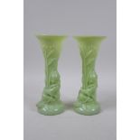 A pair of early C20th Art Nouveau milk glass spill vases in the form of a figure carrying bamboo,