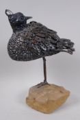 A metal sculpture of a wading bird standing on a rock pedestal, 34cm high overall