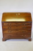 A large Georgian mahogany fall front bureau with fitted interior over four long graduated drawers