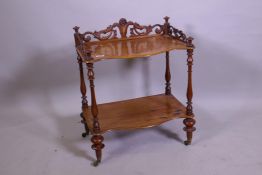 A Victorian walnut two tier occasional table, with carved and pierced three quarter gallery top