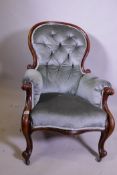 A Victorian spoon back walnut armchair with scrolled arms and shaped supports