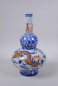 A blue and white porcelain double gourd shaped vase with iron red and gilt dragon decoration,