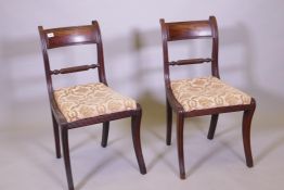 A pair of Regency mahogany side chairs, with ebony inlaid backs raised on sabre supports